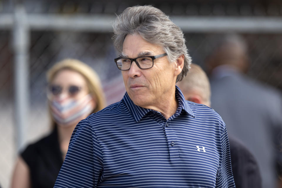 Former Energy Secretary Rick Perry waits with other guests before being let onto the tarmac to welcome President Donald Trump to Midland, Texas Wednesday afternoon July 29, 2020. (Ben Powell/Odessa American via AP)