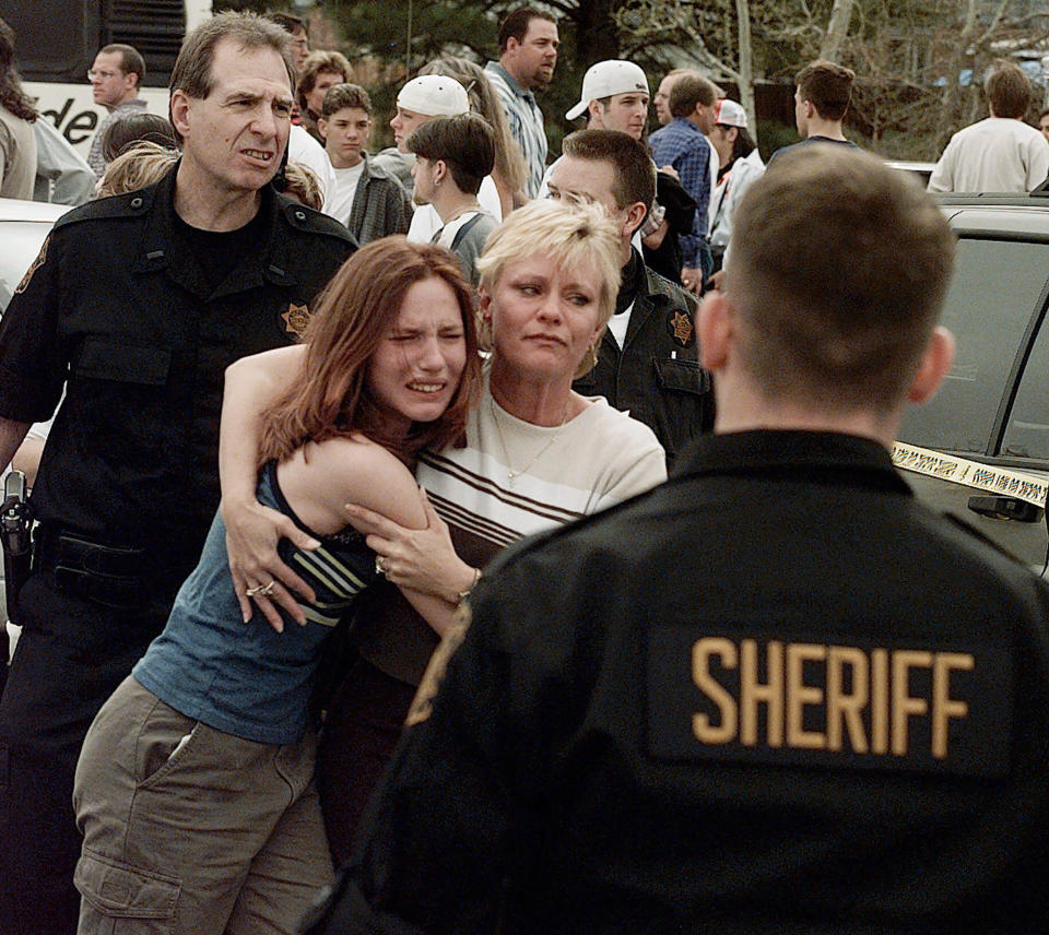 FILE - A woman embraces her daughter after they were reunited following a shooting at Columbine High School in Littleton, Colo., on April, 20, 1999. Twenty-five years later, The Associated Press is republishing this story about the attack, the product of reporting from more than a dozen AP journalists who conducted interviews in the hours after it happened. The article first appeared on April 22, 1999. (AP Photo/Ed Andrieski, File)