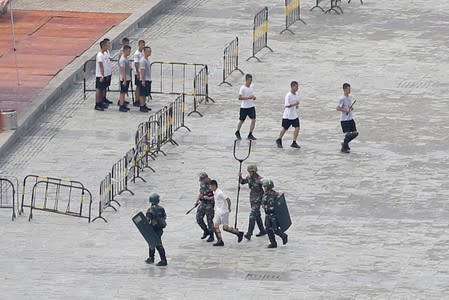 FILE PHOTO: Chinese servicemen attend a crowd control exercise at the Shenzhen Bay Sports Center in Shenzhen across the bay from Hong Kong