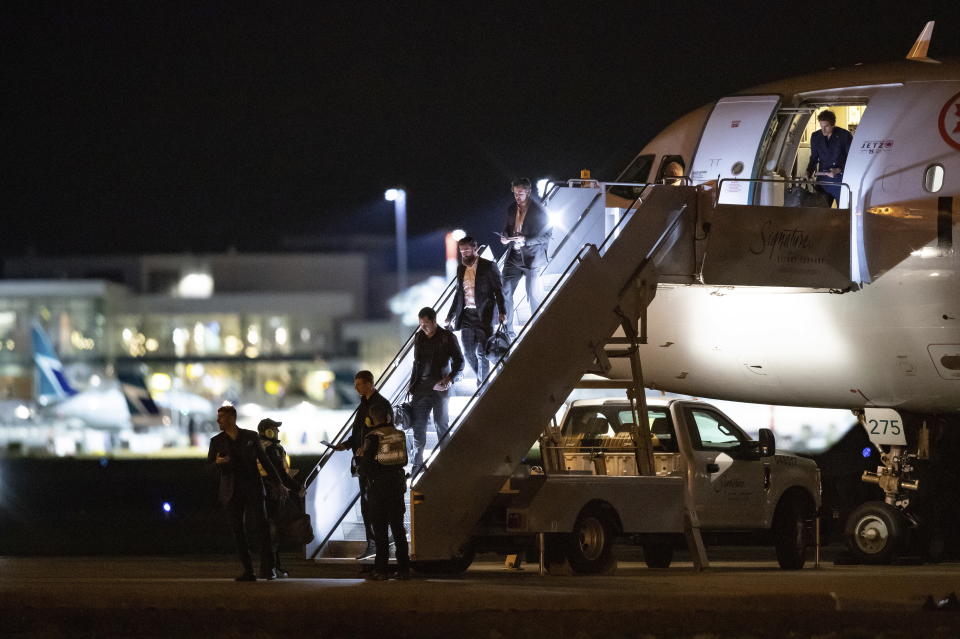 Vancouver Canucks players step off the NHL hockey team's charter plane after returning from Phoenix, at Vancouver International Airport in Richmond, British Columbia, Thursday, March 12, 2020. From bottom left are Louis Domingue, Tyler Myers, Bo Horvat, Jordie Benn, Tanner Pearson and Loui Eriksson. The NHL has suspended the season due to concerns about the new coronavirus. (Darryl Dyck/The Canadian Press via AP)