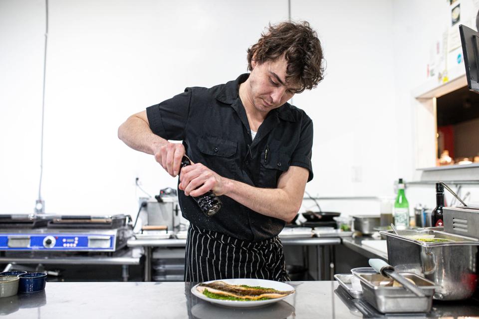 Chef Will BeDell prepares a plate of Michigan rainbow trout.