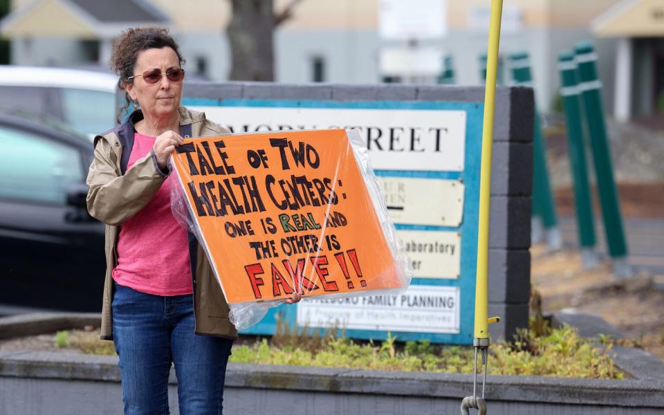 Laurie Veninger, with Indivisible Mass Coalition, demonstrates outside Abundant Hope Pregnancy Resource Center during an open house at the anti-abortion counseling center on June 17, 2023. The center in Attleboro, Massachusetts, is located next to an abortion clinic.