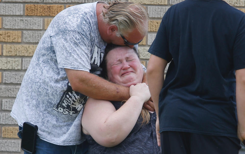 A man hugs a woman outside the Alamo Gym where parents wait to reunite with their children. (Photo: Michael Ciaglo/Houston Chronicle via AP)