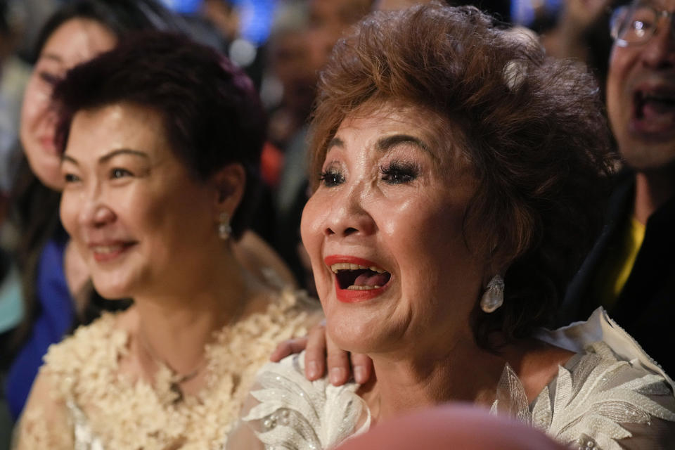 Janet Yeoh, derecha, madre de Michelle Yeoh, celebra después de que su hija ganó el Oscar a mejor actriz en la 95a edición de los Premios de la Academia en Los Angeles, en un evento en un cine de Kuala Lumpur, Malasia, el lunes 13 de marzo de 2023. (Foto AP/Vincent Thian)