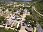 This July 6, 2019, photo shows the Fish Creek Mobile Home Park next to the Yampa River and bike path in Steamboat Springs, Colo. Some Colorado towns are taking action to preserve their remaining mobile home parks. Cities, counties and housing authorities, such as the Yampa Valley Housing Authority in Steamboat Springs, are buying mobile home parks to preserve affordable housing for residents as other mom-and-pop park owners sell out to developers or investors.(Matt Stensland/The Colorado Sun via AP)