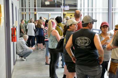 Residents of the nearby towns of Cache Creek and Ashcroft who have fled wild fires wait to be registered at an evacuation center in Kamloops, BC, Canada July 8, 2017. REUTERS/Dennis Owen