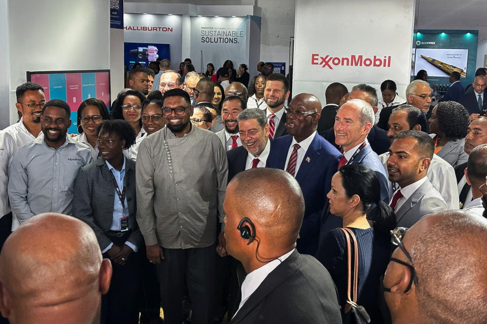 Guyana's president Irfaan Ali and Exxon's Guyana country chief Alistair Routledge smile for a picture near an Exxon stand at Guyana's International Energy Conference in Georgetown, Guyana, February 14, 2023. To match Special Report EXXON MOBIL-GUYANA/ REUTERS/Sabrina Valle