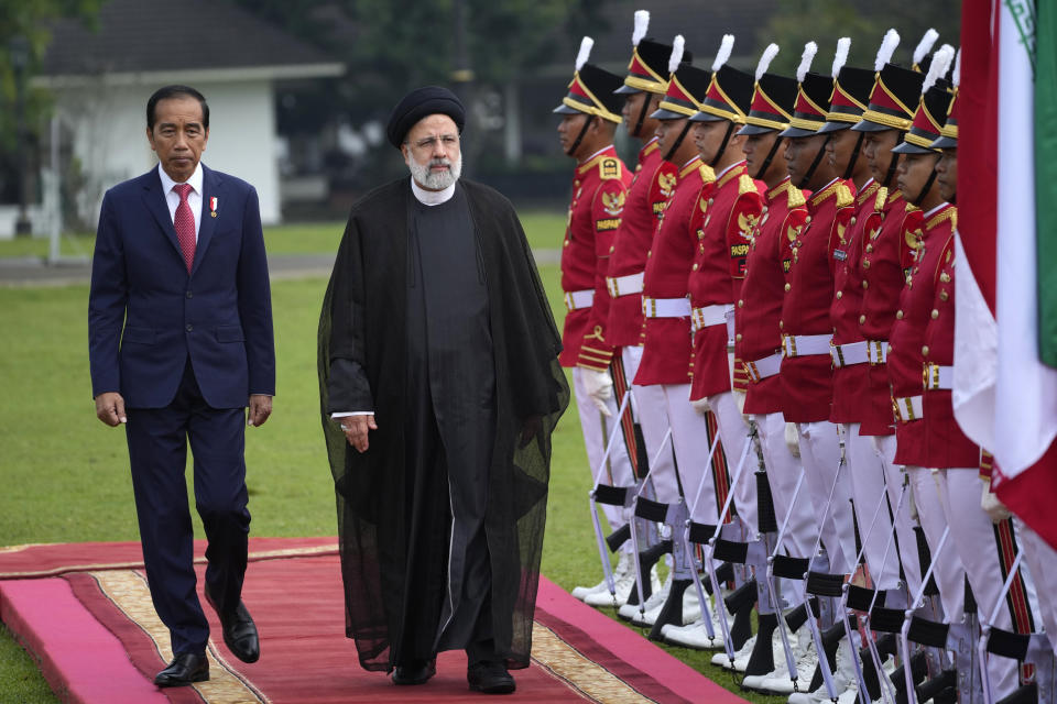 Iran's President Ebrahim Raisi, center, accompanied by Indonesian President Joko Widodo, left, inspects an honor guard upon his arrival at the Presidential Palace in Bogor, West Java, Indonesia, Tuesday, May 23, 2023.(AP Photo/Achmad Ibrahim)