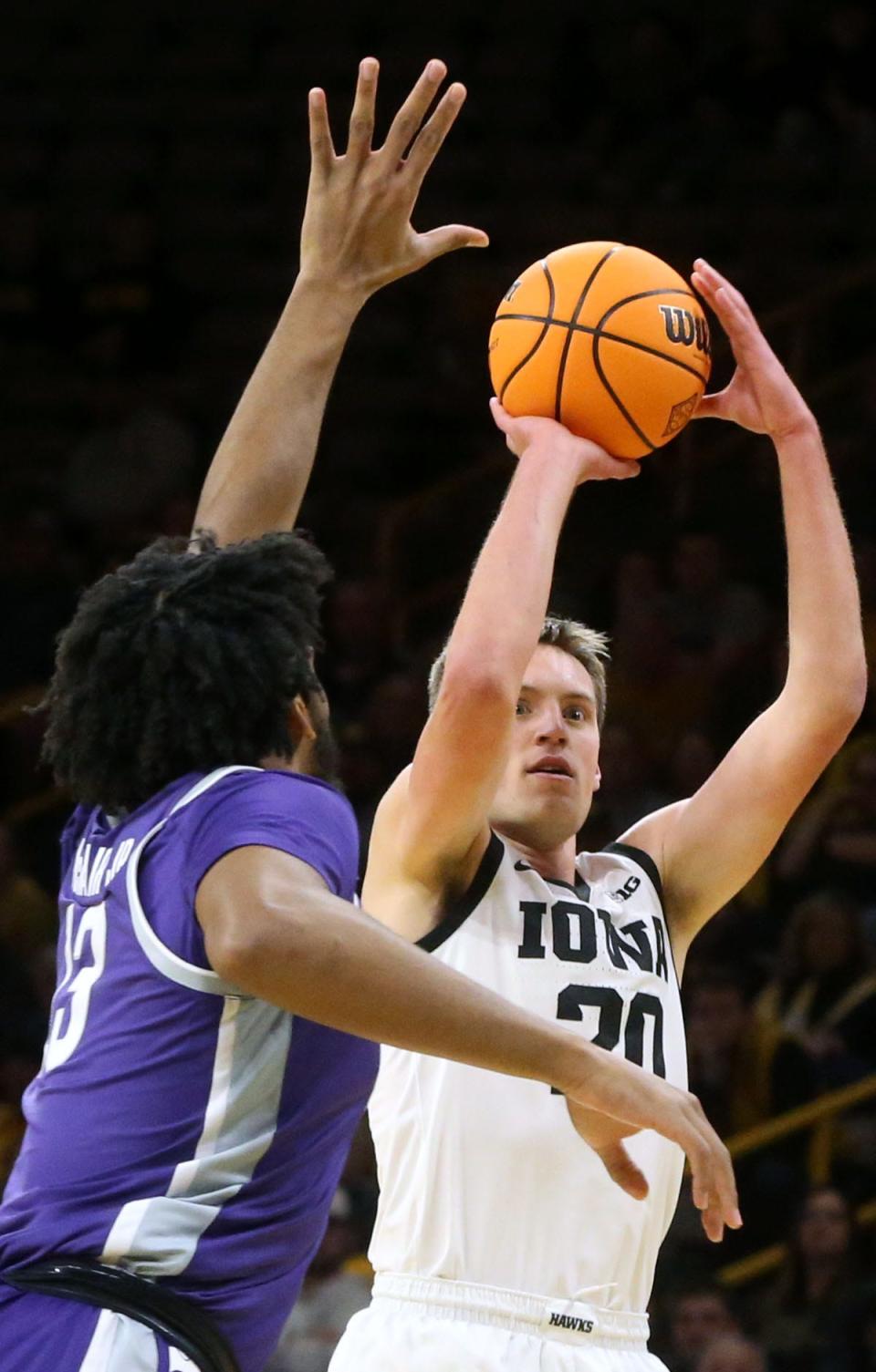 Iowa’s Payton Sandfort (20) shoots over Kansas State's Will McNair in a first-round NIT game Tuesday, at Carver-Hawkeye Arena in Iowa City, Iowa. Sandfort scored a career-high 30 points to lead Iowa.