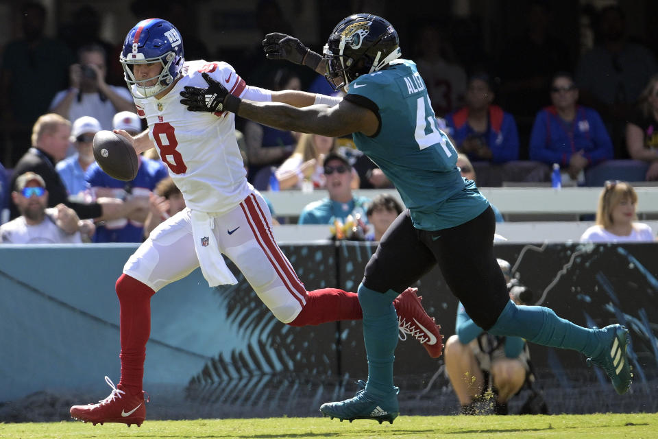 New York Giants quarterback Daniel Jones (8) scrambles away from Jacksonville Jaguars linebacker Josh Allen (41) during the first half of an NFL football game Sunday, Oct. 23, 2022, in Jacksonville, Fla. (AP Photo/Phelan M. Ebenhack)