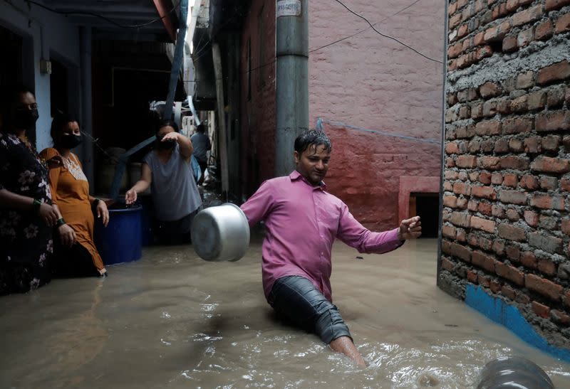 A man wades through an alley in an area flooded by the overflowing Bagmati river following heavy rains, in Kathmandu