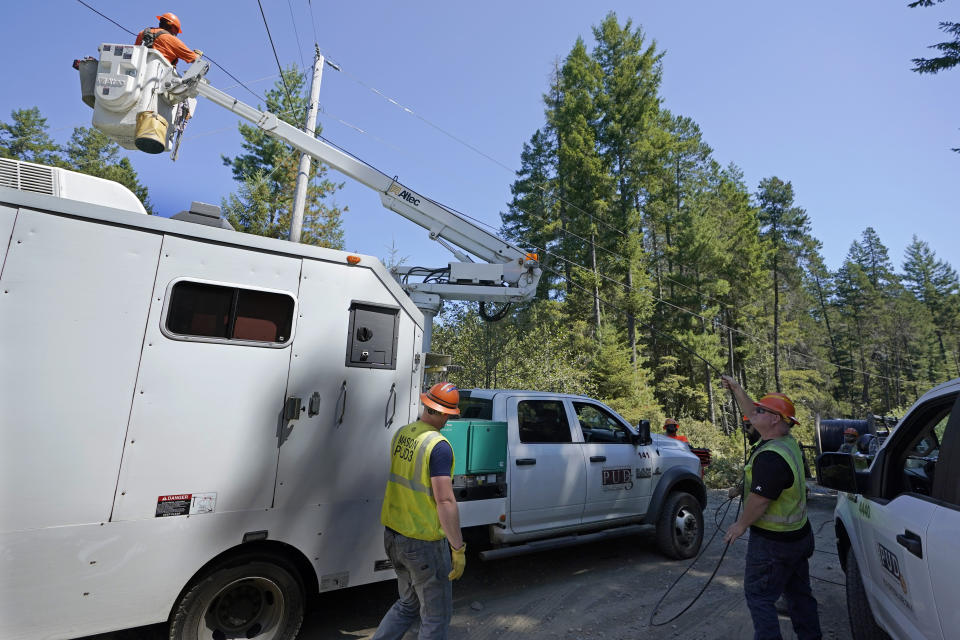 FILE - In this Wednesday, Aug. 4, 2021, file photo, workers with the Mason County (Wash.) Public Utility District install fiber optic cable, as part of a project to bring broadband internet service to homes in a rural area surrounding Lake Christine near Belfair, Wash. (AP Photo/Ted S. Warren, File)