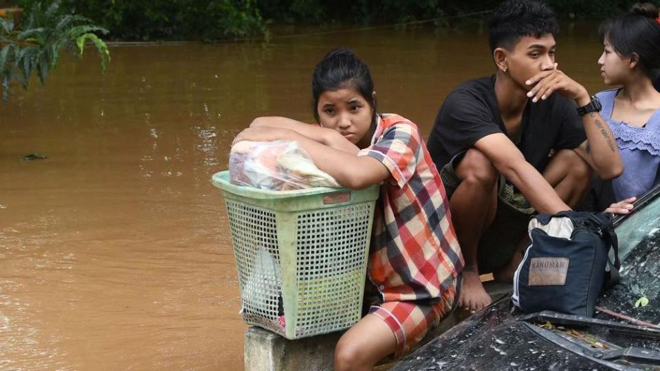 Residents walk through flood waters in Pyinmana in Myanmar's Naypyidaw region on September 13, 2024.