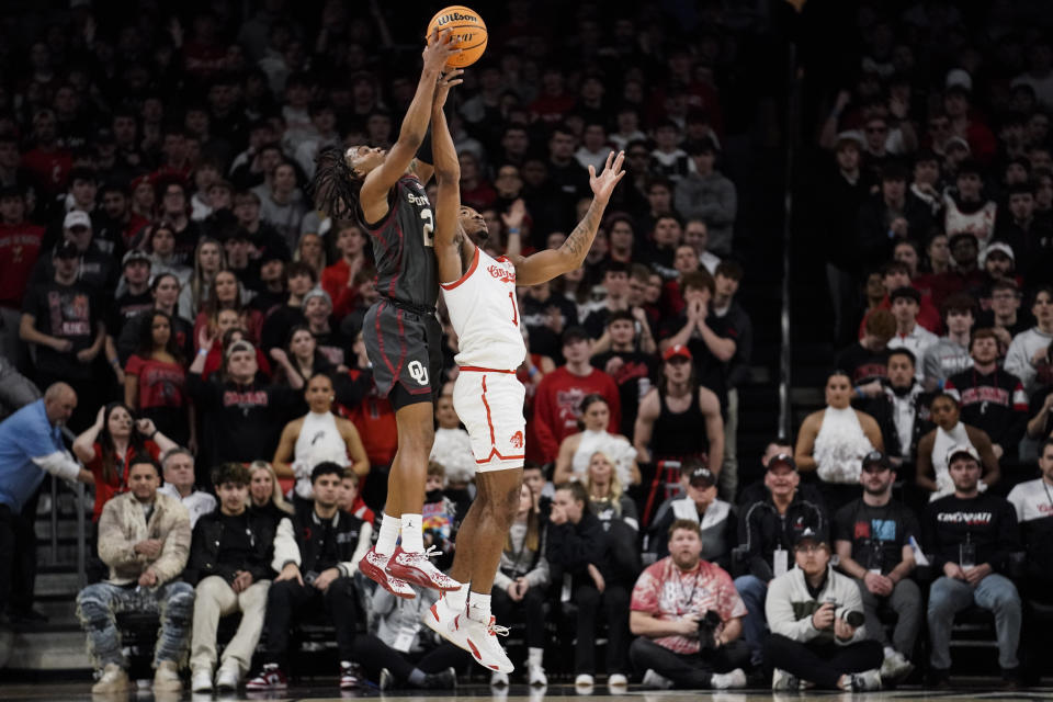 Oklahoma guard Javian McCollum, left, and Cincinnati forward Kalu Ezikpe, right, fight for the ball during the first half of an NCAA college basketball game, Saturday, Jan. 20, 2024, in Cincinnati. (AP Photo/Joshua A. Bickel)