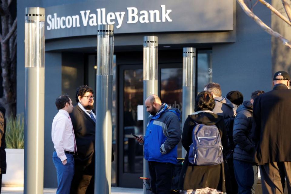 矽谷銀行被接管之後，美國金融監管機構人員在矽谷銀行門前安撫存款戶。(路透)