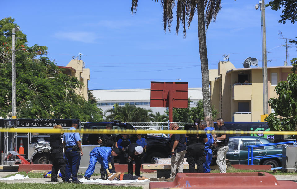 Police investigators work the scene of a multiple killing in San Juan, Puerto Rico, Tuesday, Oct. 15, 2019. Several people are reported dead following a shooting in the Rio Piedras neighborhood of San Juan. (AP Photo/Dennis M. Rivera Pichardo)