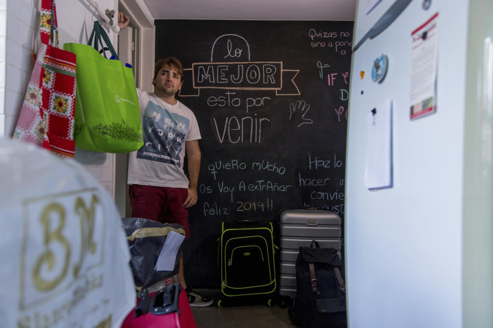 Tomas Ruiz poses for a portrait by a chalkboard covered in the Spanish messages for him: The best is yet to come," and "I Love you very much, I'm gonna miss you, Happy 2019" at his mother's house in Buenos Aires, Argentina, Tuesday, April 2, 20192019, two days before he flew to Ireland in search of work. Ruiz studied gastronomy and was employed as a cafe manager, but even working extra shifts didn't allow him to save money while living with his mother to save on rent. (AP Photo/Tomas F. Cuesta)