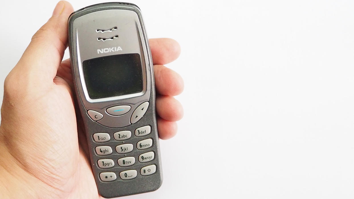  The Nokia 3210 classic phone in hand. 