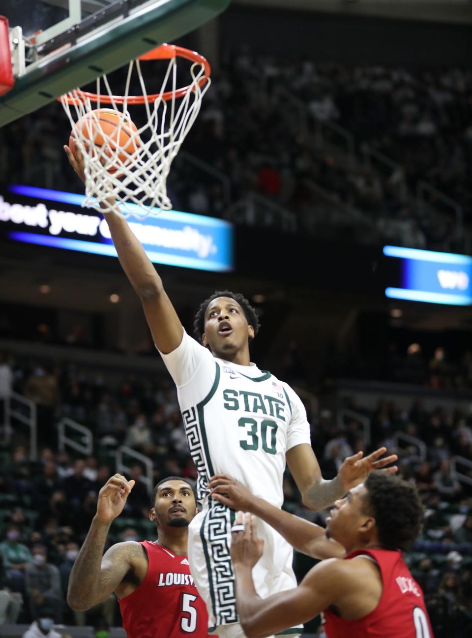 Michigan State Spartans forward Marcus Bingham Jr. (30) drives to the rim against Louisville Cardinals forward Malik Williams (5) and guard Noah Locke (0) during first half action Wednesday, Dec. 1, 2021, at the Breslin Center.