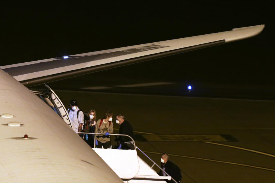 Passengers from the Australian cruise ship Greg Mortimer, board a plane to be flown to Australia at the international airport in Montevideo, Uruguay, Saturday, April 11, 2020. Uruguay evacuated Australians and New Zealanders Friday from the cruise ship that has been anchored off the South American country coast since March 27 with more than half its passengers and crew infected with the new coronavirus. (AP Photo/Matilde Campodonico)