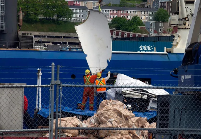 Debris from the Titan submersible, recovered from the ocean floor near the wreck of the Titanic, is unloaded from the shore (AP)