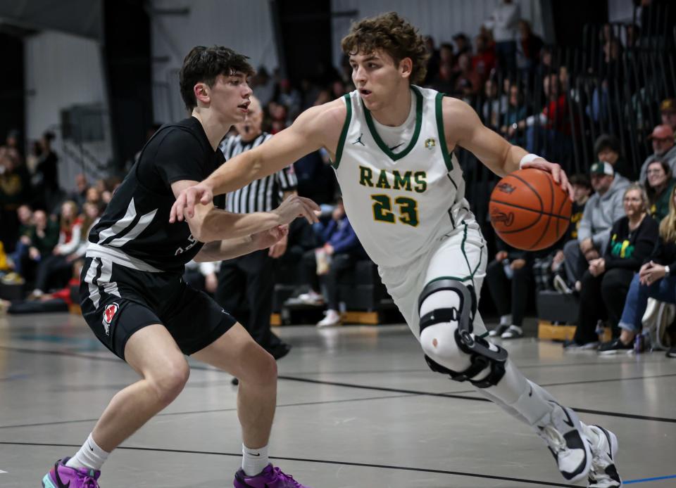Graham Junge of Flat Rock drives the baseline against New Boston Huron's Zennon Grant, during a 58-21 Flat Rock victory Wednesday in the semifinals of the Division 2 District at Summit Academy.