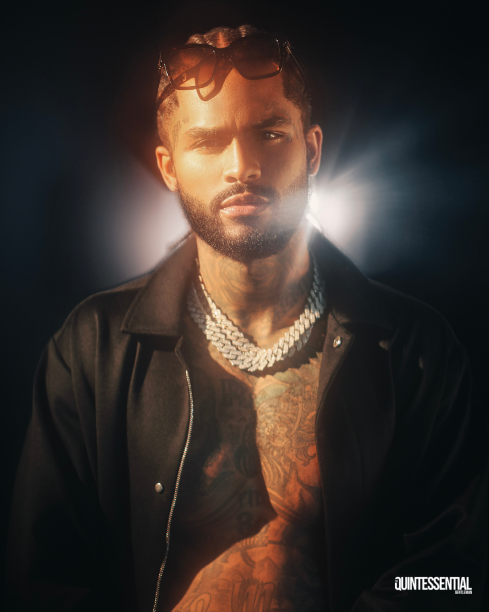 Dave East in The Quintessential Gentleman 2022 October style issue wearing opened black jacket, cuban link chains and shades