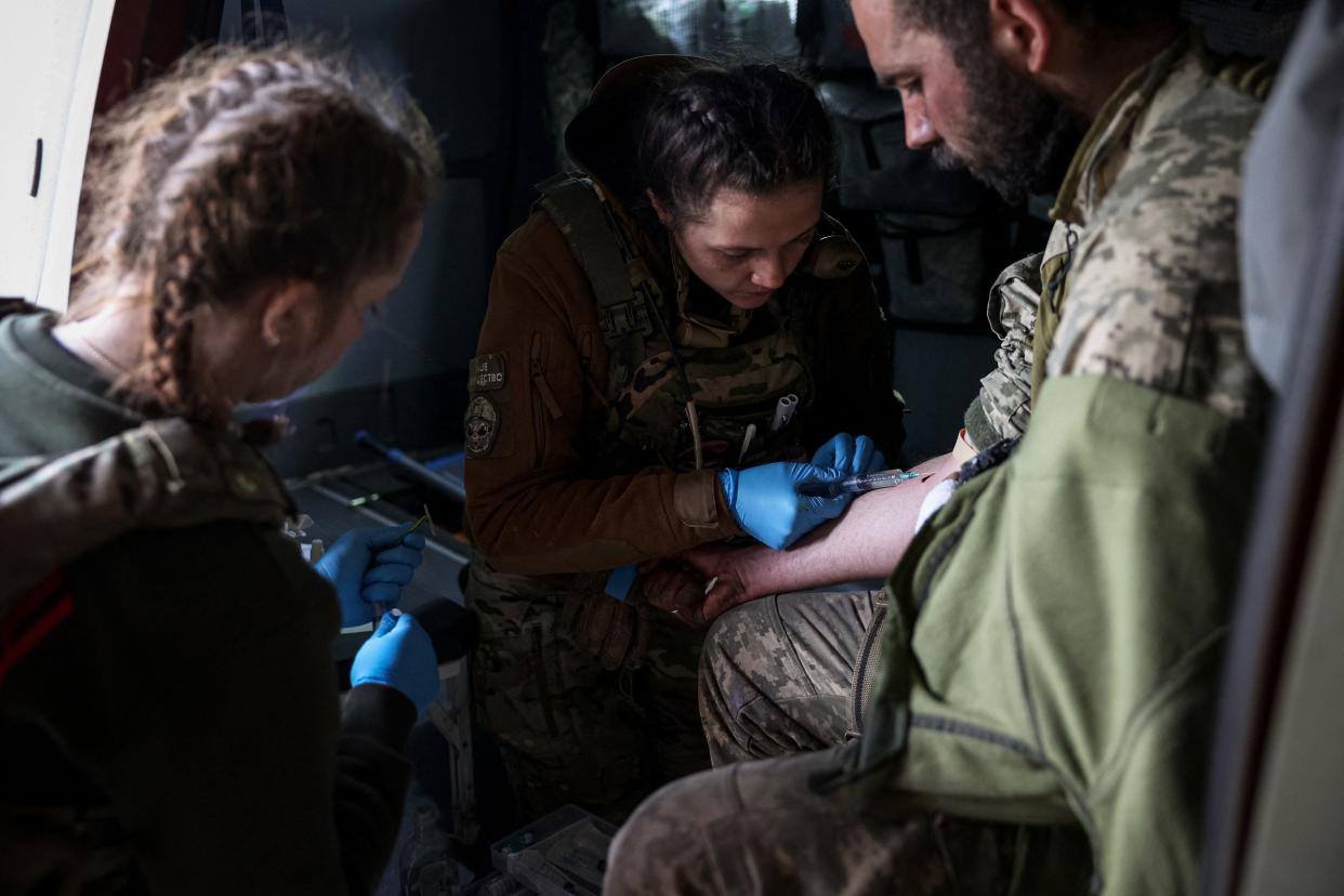 Medics treat a wounded Ukrainian serviceman at a frontline medical stabilisation point near Bakhmut, Donetsk region (AFP via Getty Images)