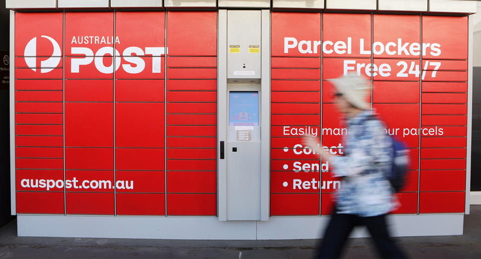 Person walking past Australia Post lockers.