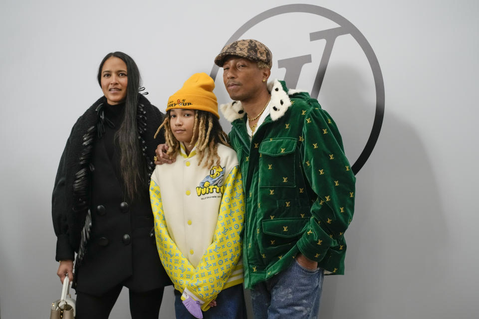 Helen Lasichanh, from left, Rocket Ayer Williams and Pharrell Williams attend the Louis Vuitton Fall/Winter 2023-2024 ready-to-wear collection presented Monday, March 6, 2023 in Paris. (AP Photo/Christophe Ena)