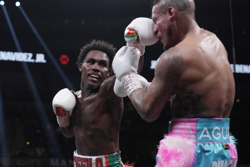 Jermall Charlo, left, lands a left on Jose Benavidez Jr., right, during a middleweight boxing match Saturday, Nov. 25, 2023, in Las Vegas. (AP Photo/John Locher)