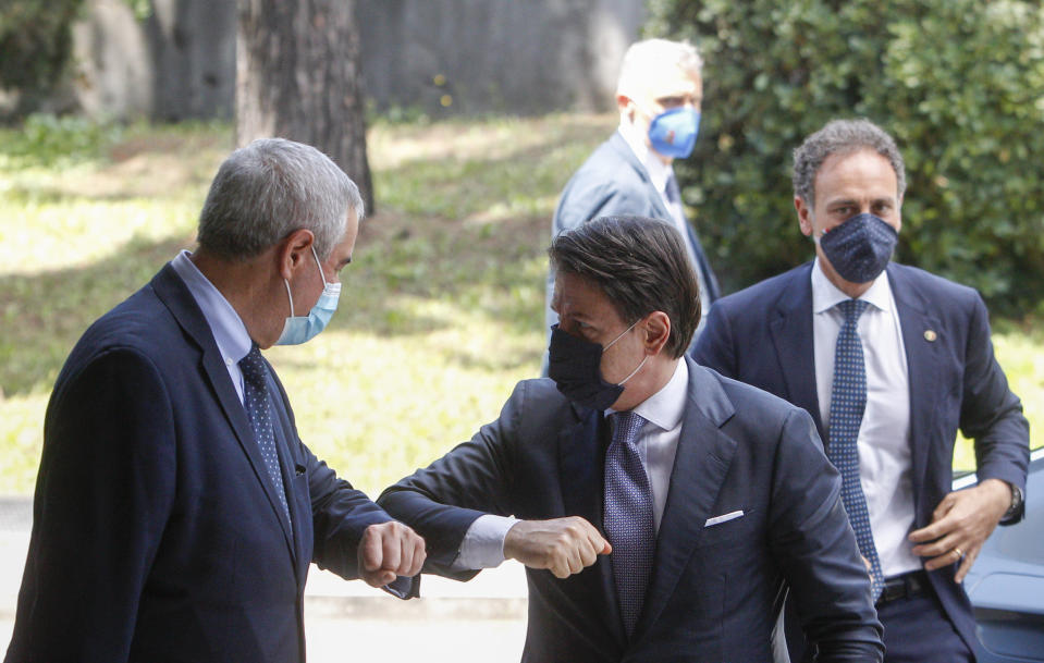 Italian Premier Giuseppe Conte, right, touch elbows with Civil Protection head Angelo Borrelli as he arrives for a thanksgiving ceremony dedicated to physicians and nurses, in Rome, Monday, June 22, 2020. (AP Photo/Riccardo De Luca)