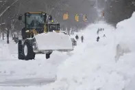 Workers use heavy equipment to clear snow from Richmond Avenue in Buffalo, N.Y., on Monday, Dec. 26, 2022. (Derek Gee/The Buffalo News via AP)