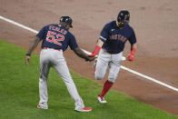 Boston Red Sox' Kyle Schwarber, right, is greeted by third base coach Carlos Febles (52) as he rounds the bases on his home run during the second inning of a baseball game against the Baltimore Orioles, Tuesday, Sept. 28, 2021, in Baltimore. (AP Photo/Nick Wass)