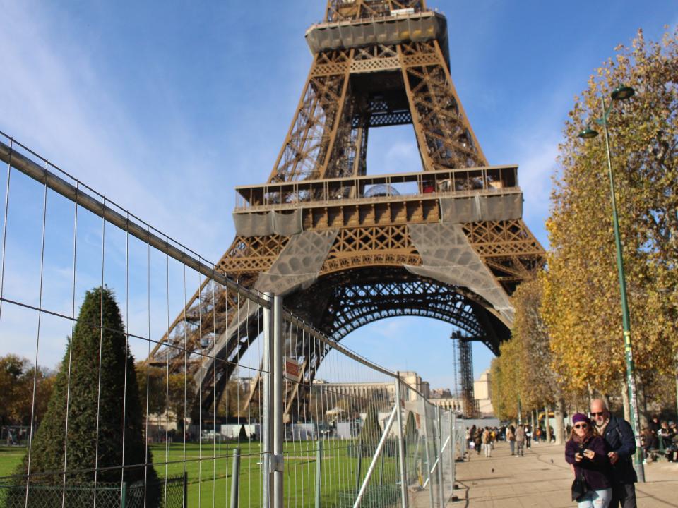 A couple takes a selfie in front of the Eiffel Tower.