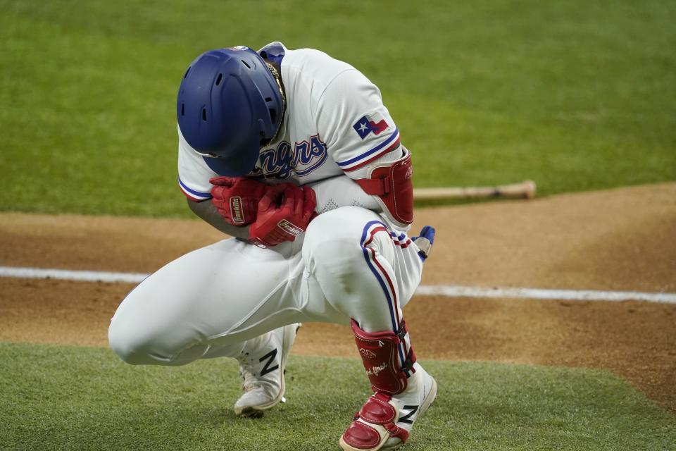 Texas Rangers' Adolis Garcia grabs his left arm after being hit by a pitch from Houston Astros' Cristian Javier in the third inning of a baseball game in Arlington, Texas, Monday, Sept. 13, 2021. Garcia continued playing in the game. (AP Photo/Tony Gutierrez)