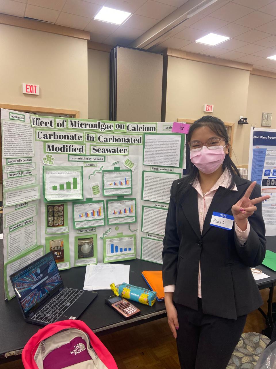 North Quincy High School sophomore Anna Li stands in front of her poster board at the Region V Science and Engineering Fair.