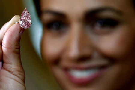 A model poses with the "Unique Pink", a 15.38 carats vivid pink diamond, at Sotheby's auction house in Geneva, Switzerland May 9, 2016. REUTERS/Denis Balibouse/File Photo