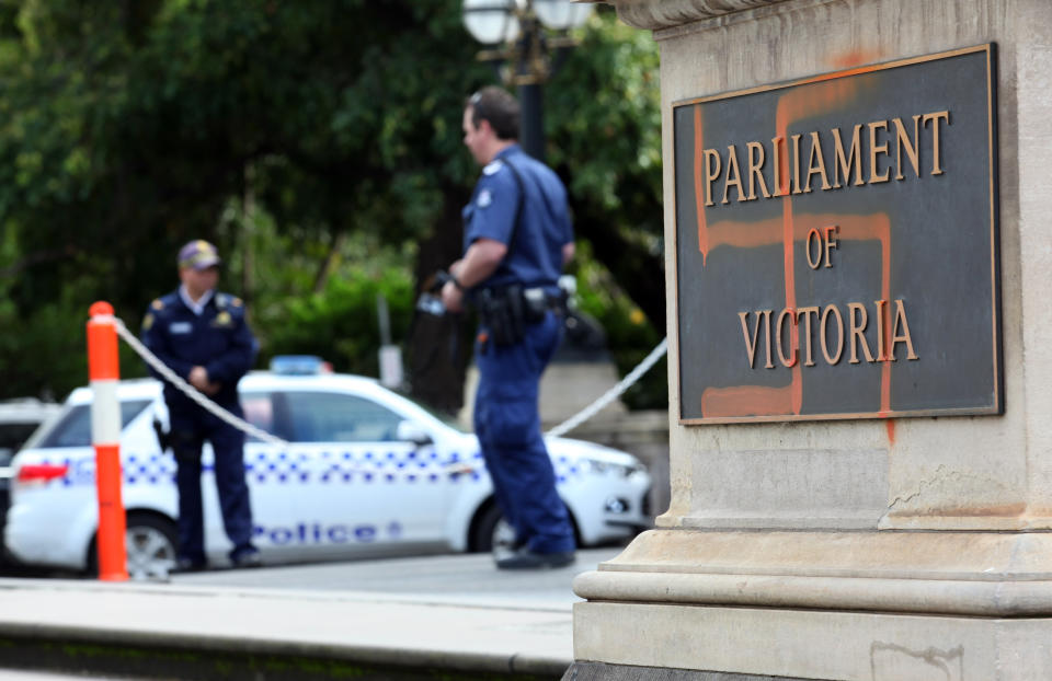 Police inspect a spray-painted swastika on the front of the Victorian State Parliament in 2012. 