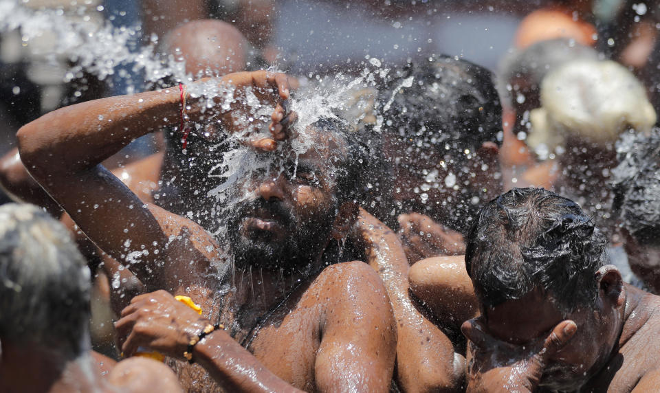 Homeless Sri Lankans bathe in a queue before they are transported to an isolation center as a measure to prevent the spread of the new coronavirus during a lockdown in Colombo, Sri Lanka, Friday, April 17, 2020. Sri Lankan authorities claim they have largely managed to prevent community spreading through proper identification and isolation of people who came into contact with COVID-19 patients. (AP Photo/Eranga Jayawardena)