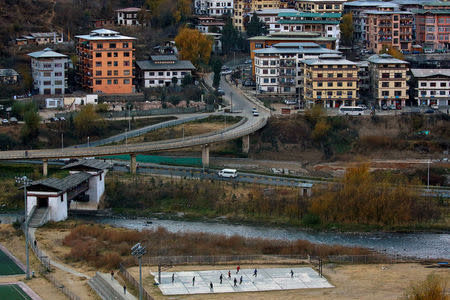 Youths play football near a highway in the capital city of Thimphu, Bhutan, December 11, 2017. REUTERS/Cathal McNaughton