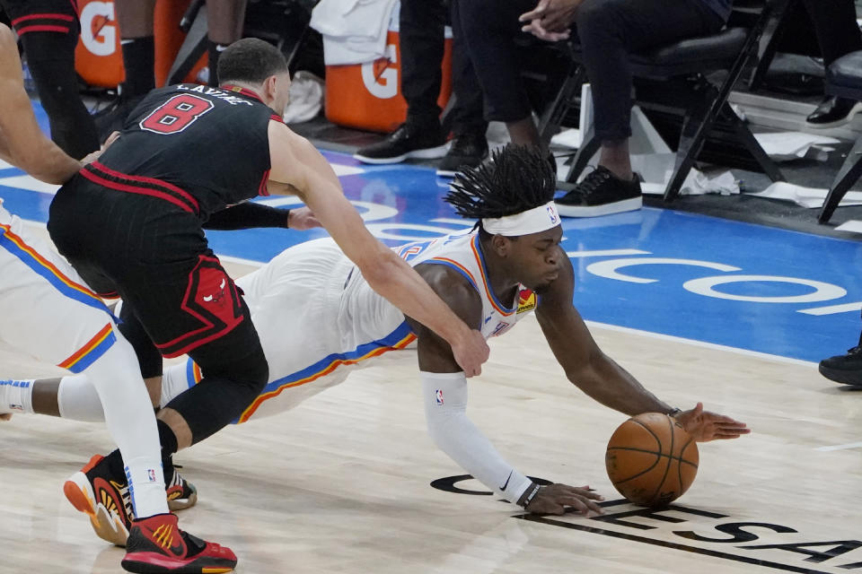 Oklahoma City Thunder forward Luguentz Dort, right, dives for a ball in front of Chicago Bulls' Zach LaVine (8) during the second half of an NBA basketball game Friday, Jan. 15, 2021, in Oklahoma City. (AP Photo/Sue Ogrocki)