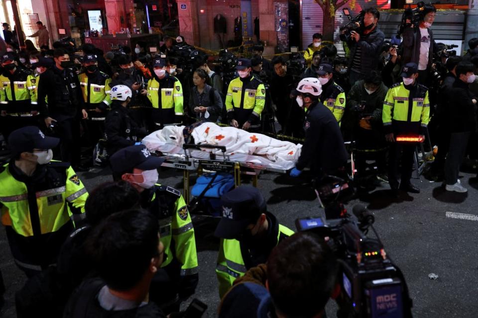 <div class="inline-image__caption"><p>Rescue team members move a body at the scene where dozens of people were injured in a stampede during a Halloween festival in Seoul.</p></div> <div class="inline-image__credit">KIM HONG-JI</div>