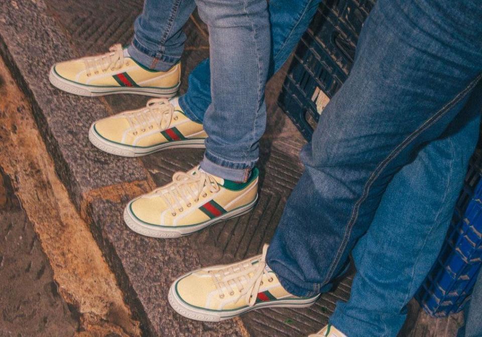 Après le succès de son modèle Ace, Gucci revient en force sur le marché de la basket avec une réédition d’une de ses archives iconiques. Baptisée Gucci Tennis 1977, le nouveau soulier imaginé par Alessandro Michele, directeur de la création de la griffe depuis 2015, reprend les codes d’un modèle rétro conçu quarante ans plus tôt, aujourd’hui exposé au Gucci Garden à Florence. À l’époque, elle s’adressait aux jet-setteurs amateurs de tennis qui parcouraient le monde pour défier leurs adversaires sur des courts ensoleillés. Aujourd’hui, on l’imagine d’avantage aux pieds d’une clientèle urbaine.Gucci Tennis 1977 : Une basket, sept déclinaisonsProposée dans différentes combinaisons de toiles et d’imprimés, avec une semelle en caoutchouc blanc décorée de deux lignes vertes, la Gucci Tennis 1977 se griffe de détails signature de la maison italienne, comme le motif GG et la bande web verte et rouge. Au total, elle se décline dans sept modèles aux designs différents : trois modèles de couleur unie, trois versions imprimées et un dernier modèle à motif Mickey Mouse. Des pièces aux allures rétro qui devraient séduire les amoureux du vintage.