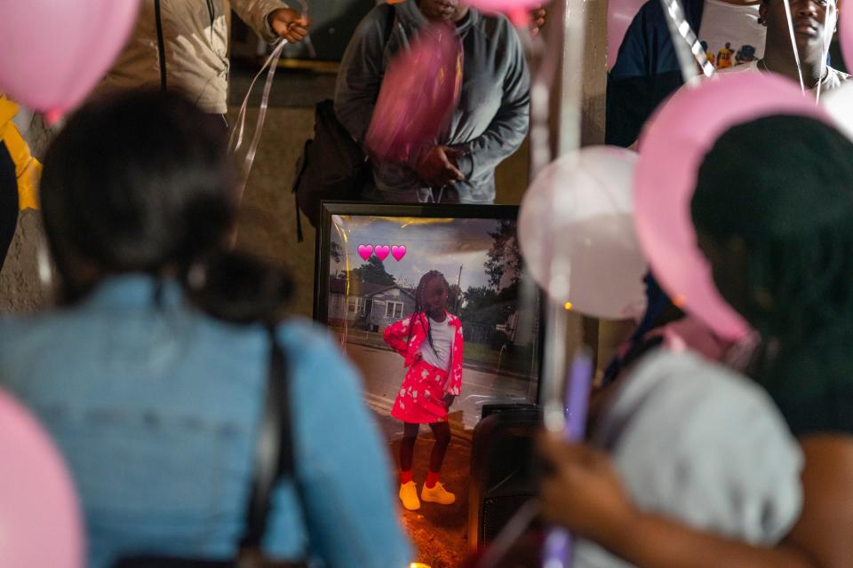 A poster of Ronziyah Atkins is seen Saturday night outside her home in Belle Glade during a vigil for her. The 8-year-old Gove Elementary student was killed Friday night in a drive-by shooting.