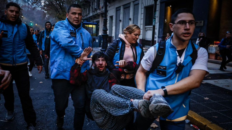 A man receives help during clashes with police