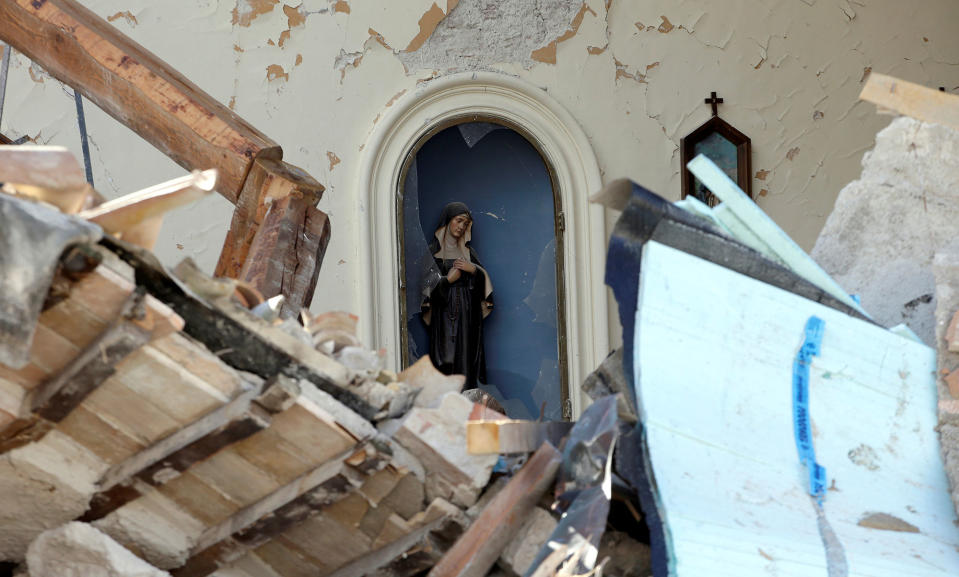 A Virgin Mary statue in a collapsed church