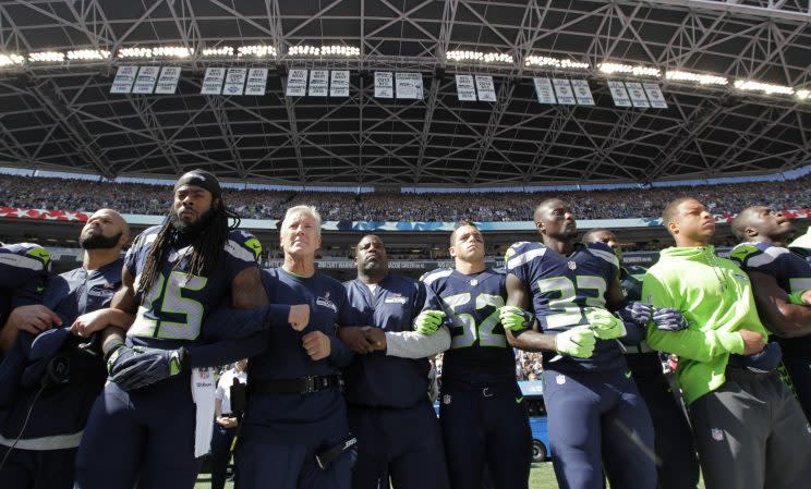 Richard Sherman (25) and the Seattle Seahawks locked arms during the national anthem in a sign of unity (AP)