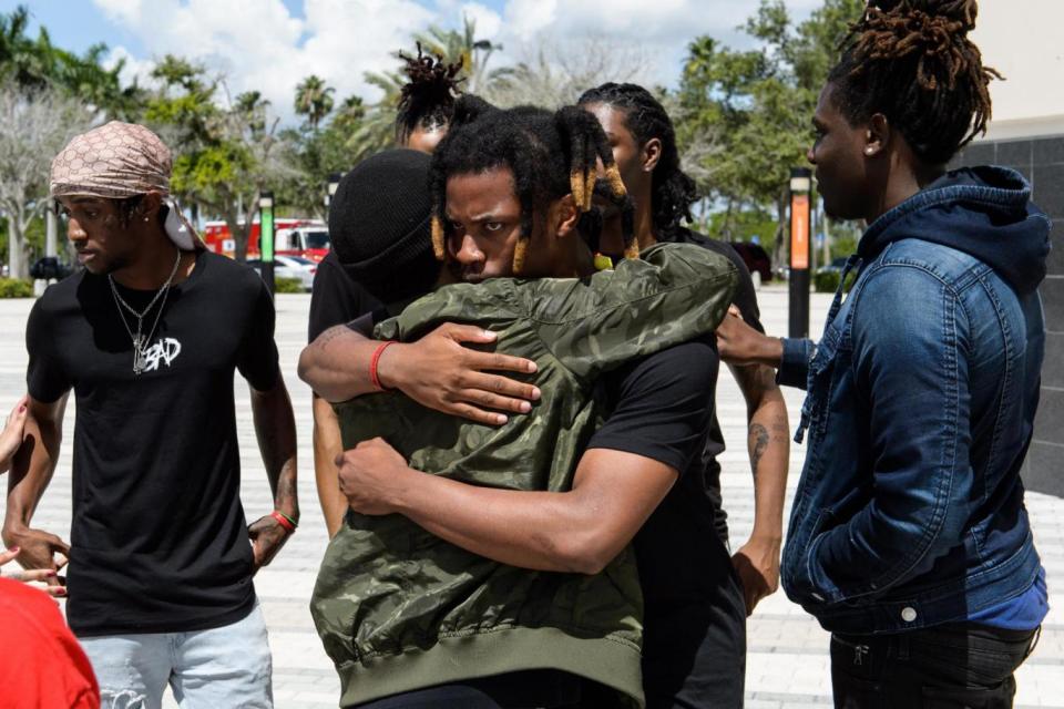 Rapper Denzel Curry hugs a friend outside the funeral and memorial (Getty Images)