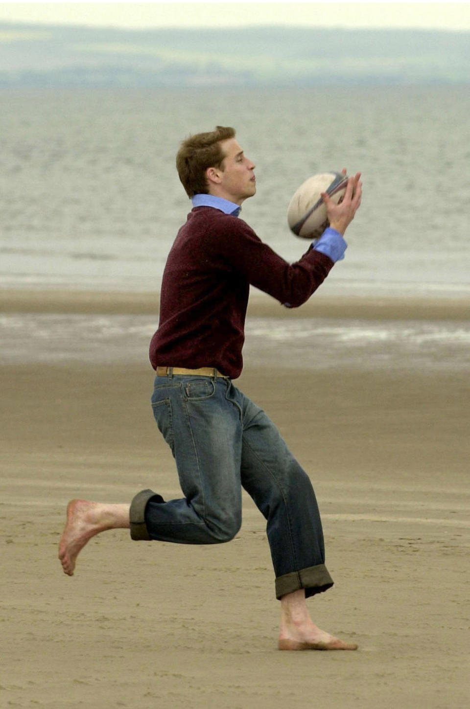 <p>Prince William catching a rugby ball on the beach at St Andrews. He and Kate will return to the beach during their week-long tour as they revisit their student days. (PA Images)</p> 